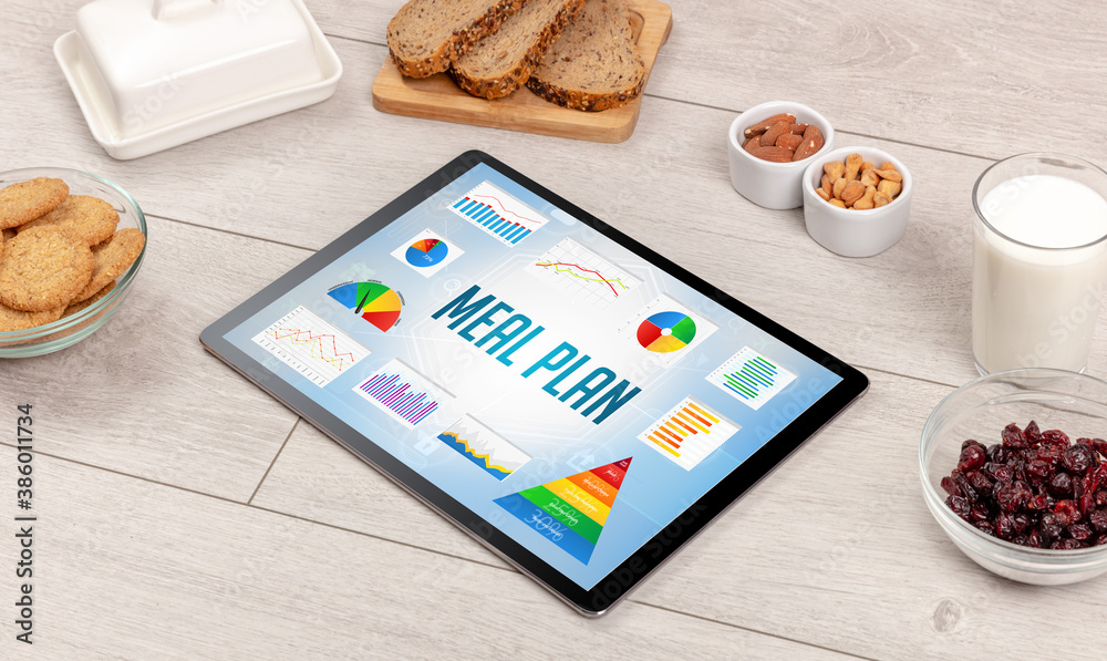Organic food and tablet pc showing MEAL PLAN inscription, healthy nutrition composition Organic food and tablet pc showing MEAL PLAN inscription, healthy nutrition composition