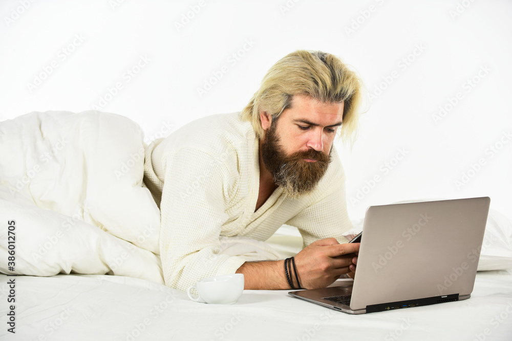 Social networks dependence. Screen Time and Insomnia. Happy hipster drink coffee in bed. Bearded man enjoy coffee and surfing internet laptop. Morning coffee routine. Social media. Modern life Social networks dependence. Screen Time and Insomnia. Happy hipster drink coffee in bed. Bearded man enjoy coffee and surfing internet laptop. Morning coffee routine. Social media. Modern life
