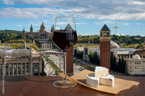 Photography Glass of red wine with brie cheese against view of  The Spain Square in Barcelon