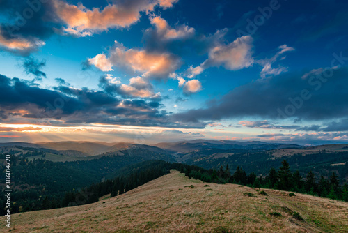 Sunset over the autumn forests in the Carpathian mountains, last sunrays painting the horizon.