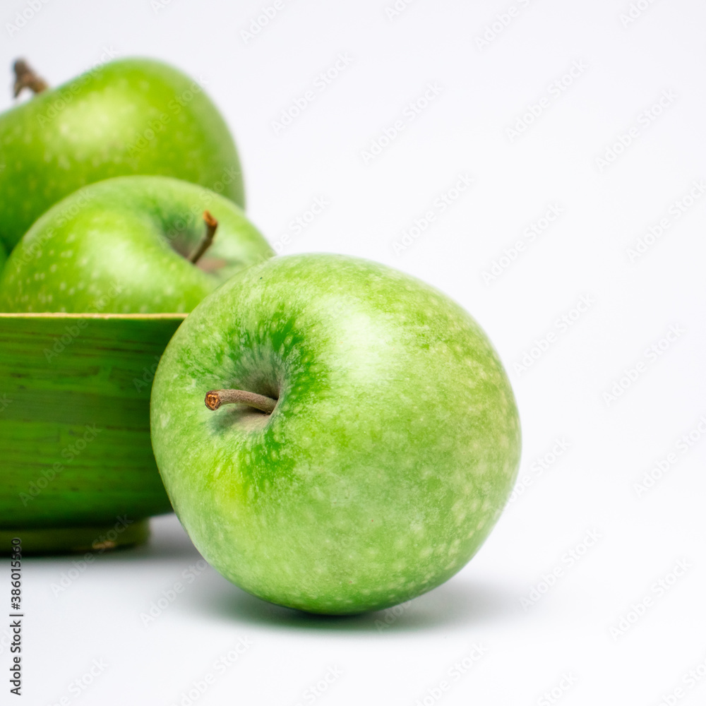 Picture of green ripe apple in wooden plate on white background. Picture of green ripe apple in wooden plate on white background.