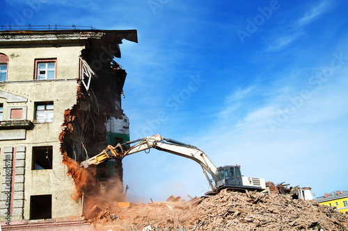 excavator demolishing a brick building. Machinery Demolishing Building