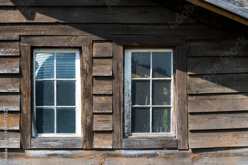 Couple of old wooden windows on a wooden facade