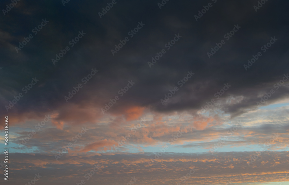 Sunset evening blue sky with pink and textured dark clouds Sunset evening blue sky with pink and textured dark clouds