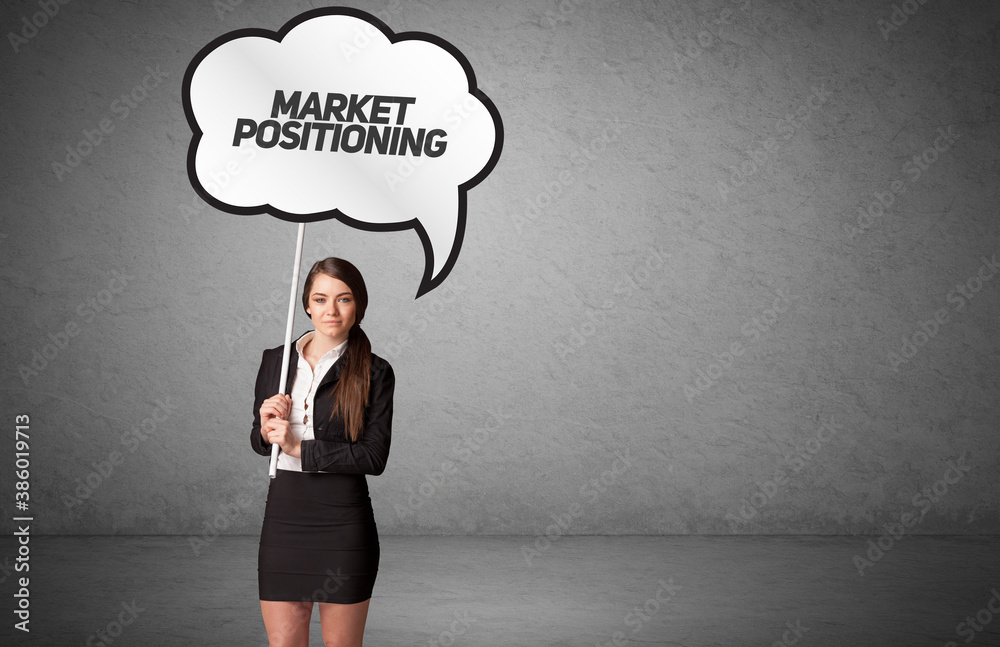 Young business person in casual holding road sign with MARKET POSITIONING inscription, new business idea concept Young business person in casual holding road sign with MARKET POSITIONING inscription, new business idea concept