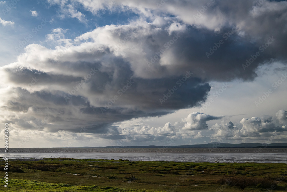 An autumnal image of a weather front over Morecambe bay, stretching from Bolton Le Sands to Walney Island, Lancashire, England