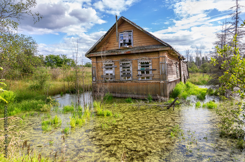 Old wooden abandoned house in a swamp
