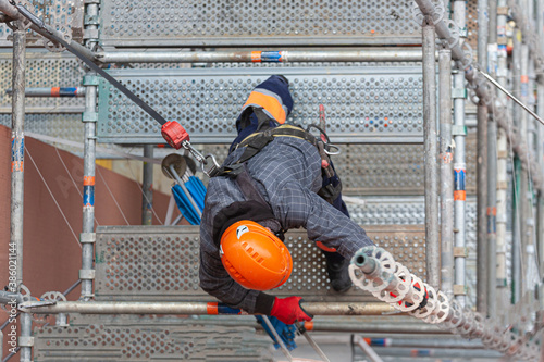 obrero de la construcción colocando un andamio de obra para reparar una fachada 