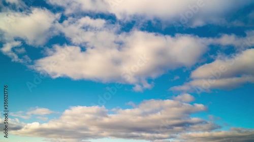 Timelapse of blue sky with floating or flying white clouds photo