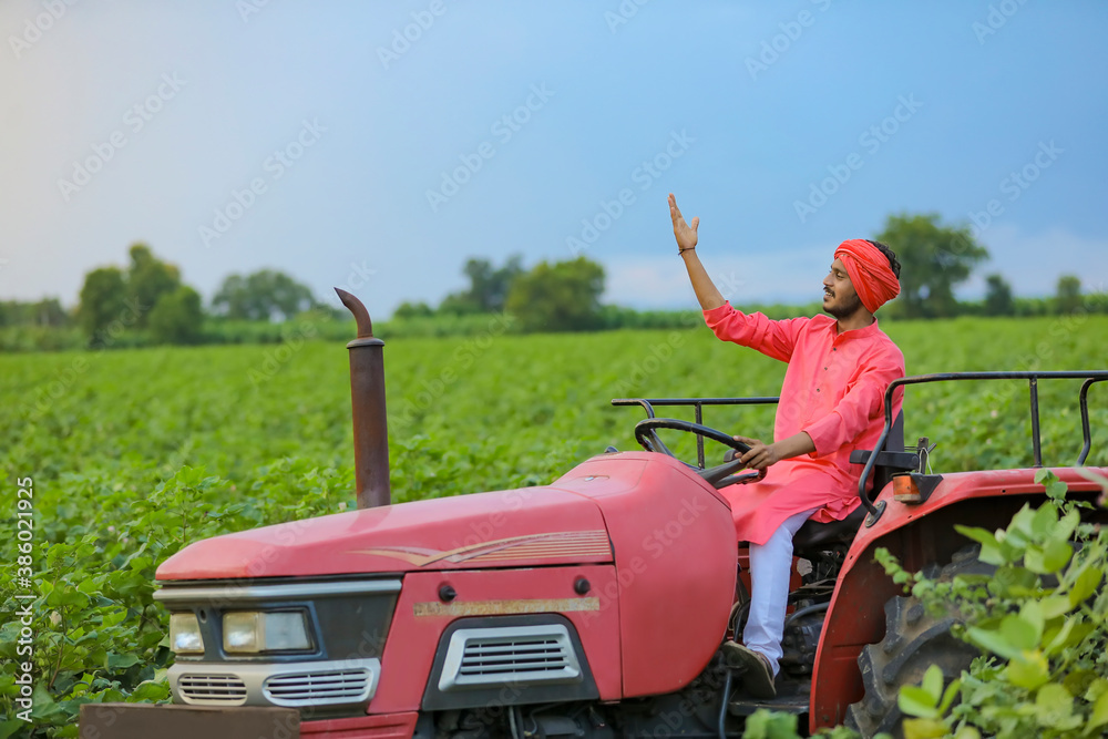Indian farmer working with tractor at field