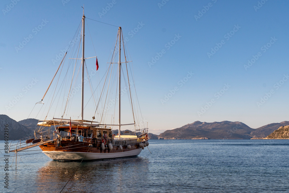 A traditional Turkish gullet boat anchoring at a small bay. Blue sky and sea. A traditional Turkish gullet boat anchoring at a small bay. Blue sky and sea.