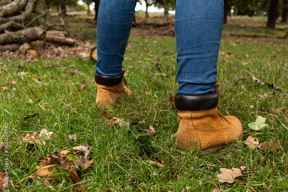 Detail photo of a pair of yellow boots walking across the countryside during the fall season Detail photo of a pair of yellow boots walking across the countryside during the fall season