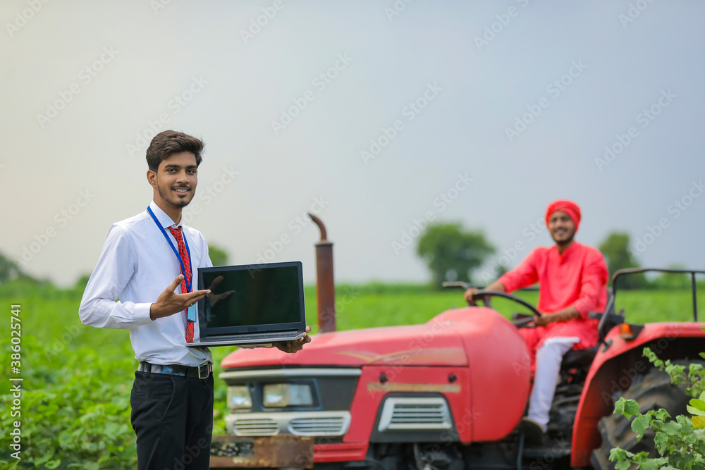 young indian agronomist showing laptop screen