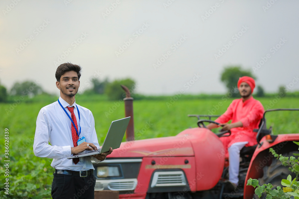 young Indian agronomist using laptop at field young Indian agronomist using laptop at field