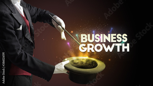Illusionist is showing magic trick with BUSINESS GROWTH inscription, new business model concept
