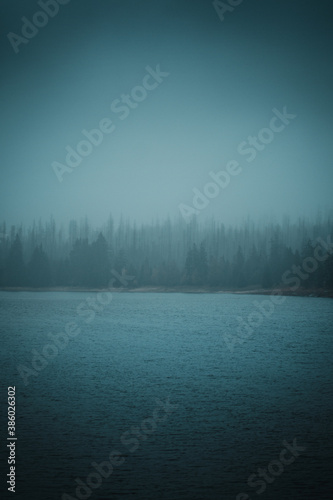 A mountain lake on a dark moody rainy winter day. Oderteich, Harz National Park, Harz mountains in Germany