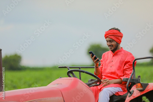 young indian farmer talking on smartphone