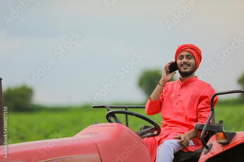 young indian farmer talking on smartphone