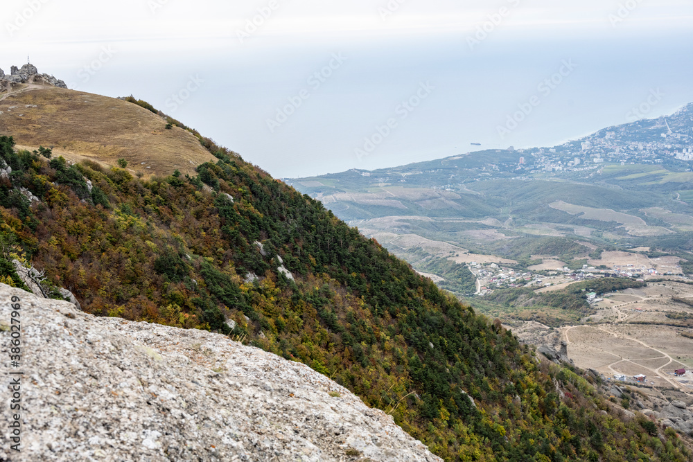 panoramic view of the mountains and the valley against the backdrop of green pine trees and autumn sky