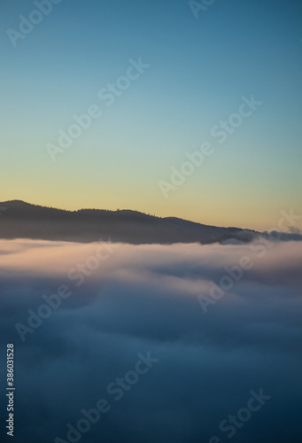 Over the clouds view, mountains in the background, sunrise