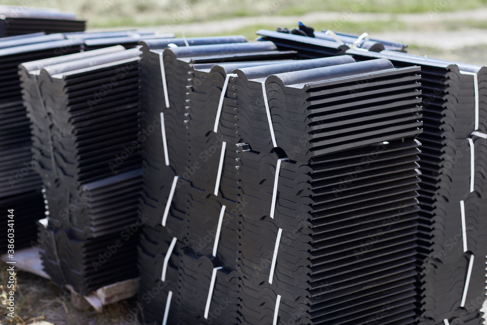 Φωτογραφία Stacks of dark modern roof tiles for covering the house