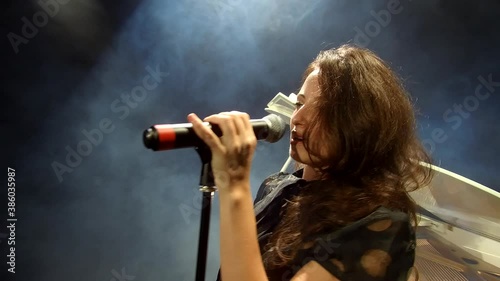 sexy performer with mic. sing a song. sensual woman singer. retro singer on stage with white piano forte. singing in microphone. pop star. professional live lead vocal performance. karaoke.