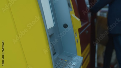 Close up female hand in protective latex glove entering pin code on the ATM machine. Banking service. Health medical care and safety, epidemic in the city.