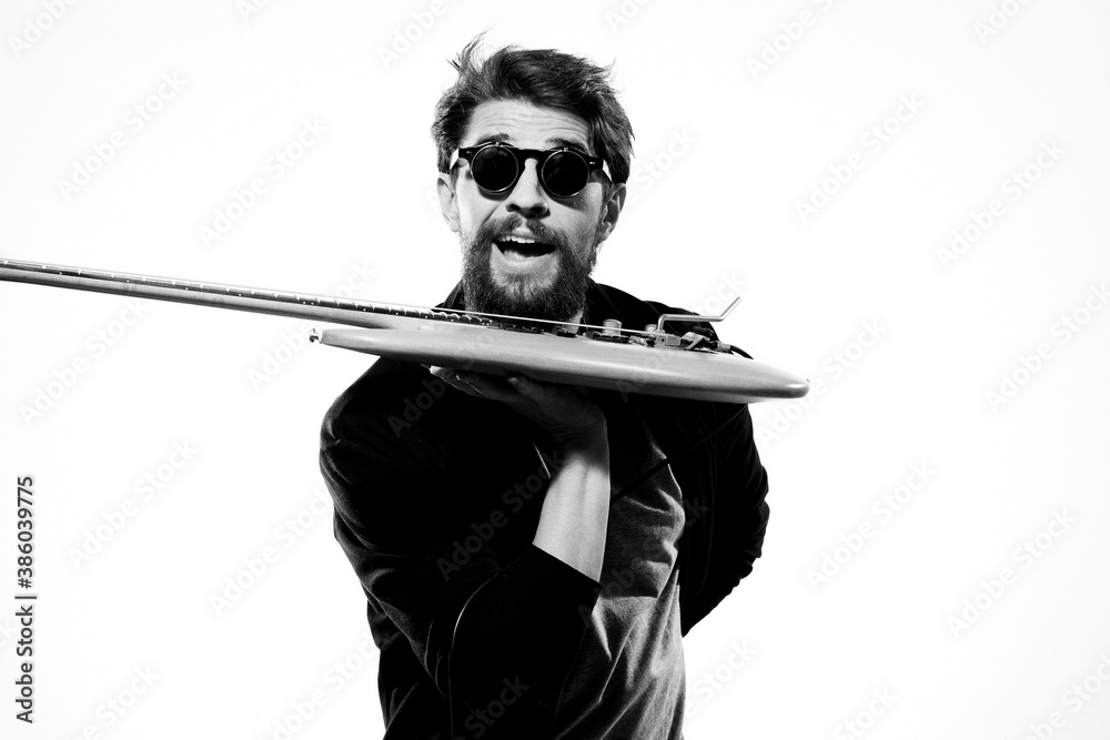 Εκτύπωση καμβά A man holds a guitar in his hands black leather jacket dark glasses music perfor