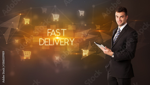 Businessman with shopping cart icons and FAST DELIVERY inscription  online shopping concept