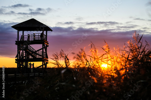 Sunrise on lake, birds watching tower in a beatiful light