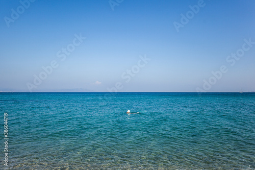 Woman wearing summer hat swimming in a sea, Kos island, Greece