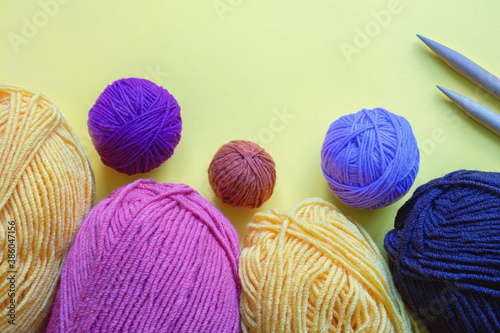Colorful clews and skeins of wool for knitting. Hobby concept. Paper background, copy space