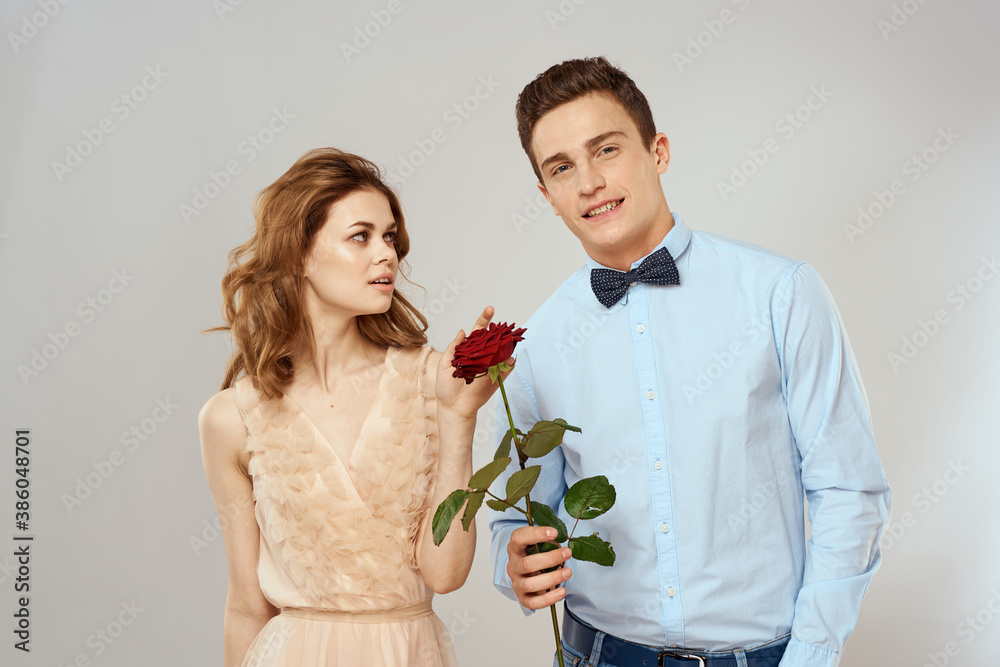 Young couple hugs romance dating lifestyle relationship light background red rose