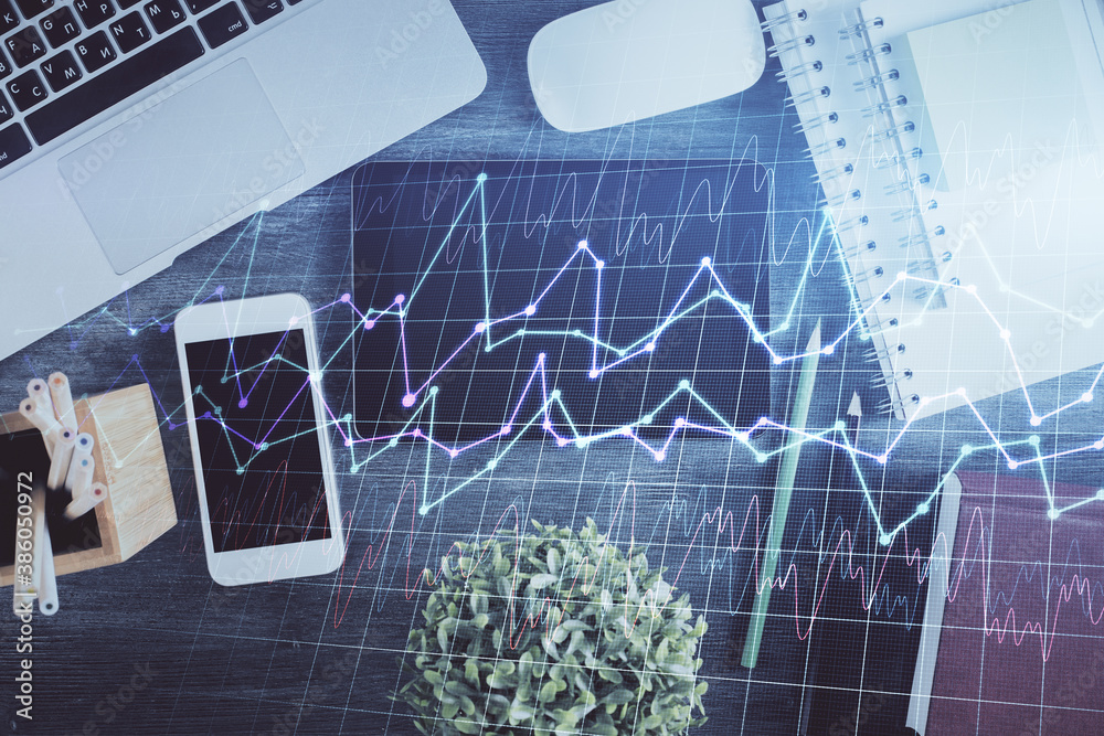 Double exposure of forex chart hologram over desktop with phone. Top view. Mobile trade platform concept. Double exposure of forex chart hologram over desktop with phone. Top view. Mobile trade platform concept.