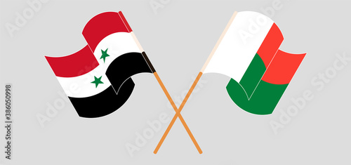 Crossed and waving flags of Madagascar and Syria