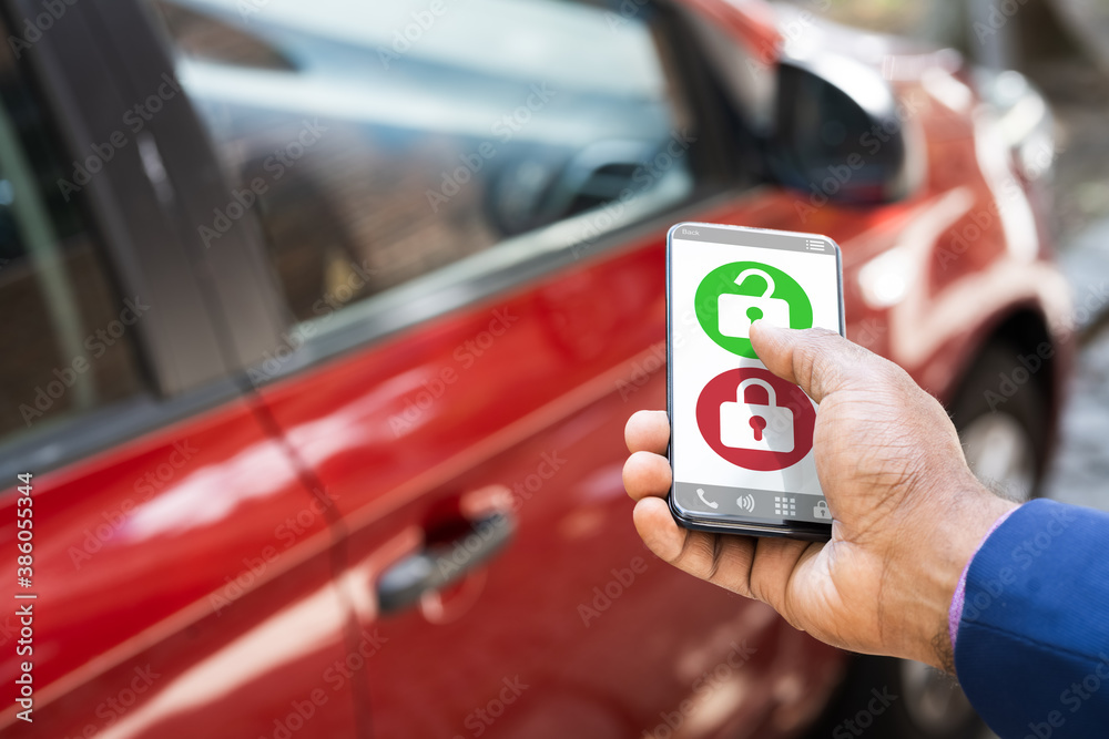 Obraz premium African Man Unlocking Car Using Smartphone