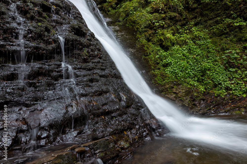 Wonderful waterfall on the mountain river Carpathians. Sopit Waterfall, National Park of Skole Beskydy, Ukraine. Carpathian river, fast current, crystal water. Long exposure shot.