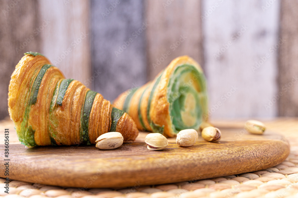 Photo of a traditional freshly baked croissant filled with a delicious pistachio cream. Healthy, wholesome and good breakfast. Traditional lifestyle. Photo of a traditional freshly baked croissant filled with a delicious pistachio cream. Healthy, wholesome and good breakfast. Traditional lifestyle.