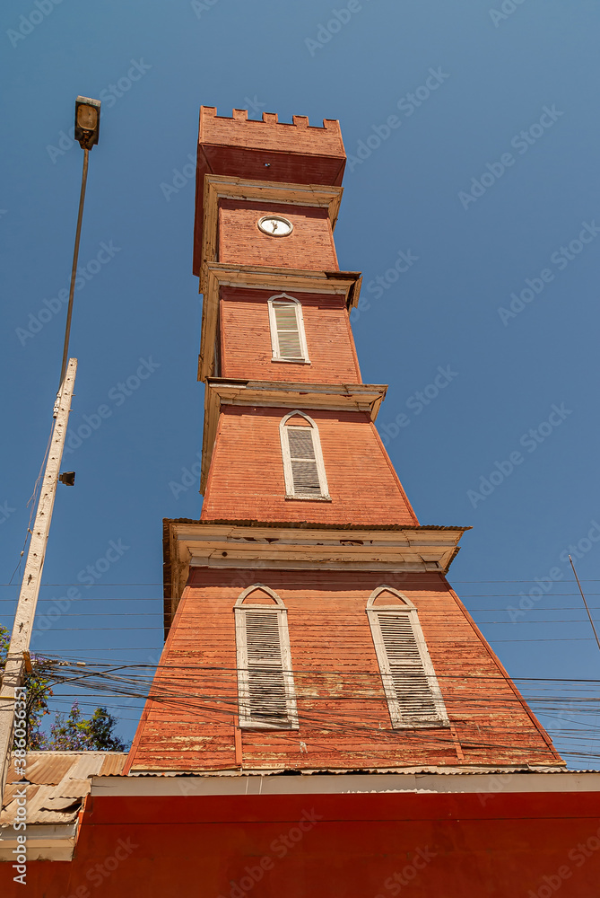 Vicuna, Chile - December 7, 2008: Downtown, Plaza Gabriela Mistral. Closeup of Red wooden Bauer clock Tower against blue sky.