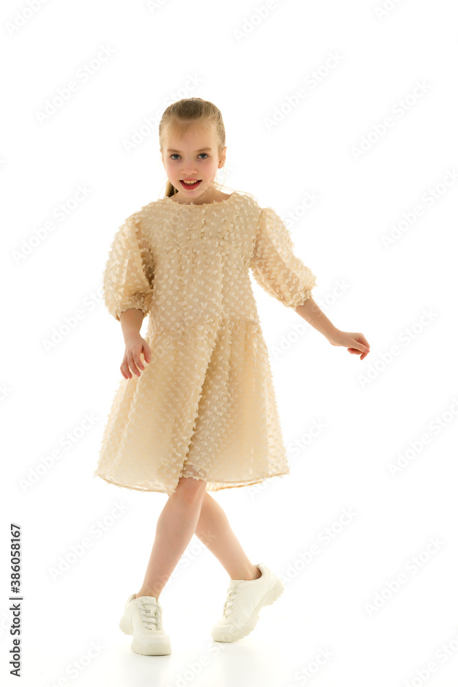 A cheerful little girl is dancing.The concept of a school of dance. A cheerful little girl is dancing.The concept of a school of dance.