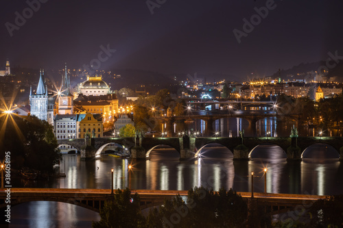 panoramic view of the illuminated city of Prague and the Vltava river and the bridges on it and the light from the street lights in the city center at night