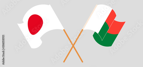 Crossed and waving flags of Madagascar and Japan
