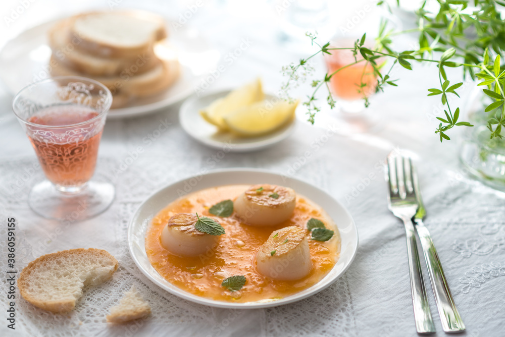 Pan Seared Sea Scallops with Orange Tomato Sauce. Glass of Rose Wine