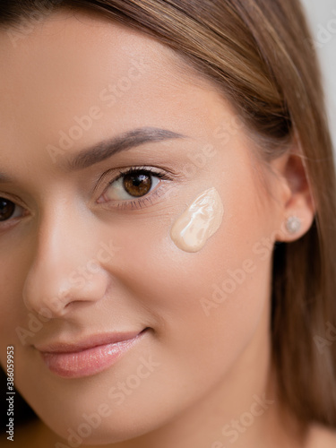 Face care and makeup, a young woman applies Foundation to the skin.