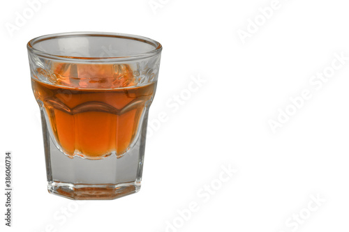 On a white background on the left side there is a glass of cognac. Close-up photographed.