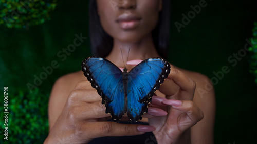 Canvas Print Young and beautiful black model exotic look with bright blue butterfly