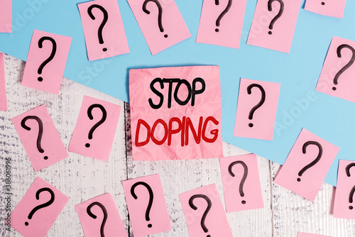 Handwriting text Stop Doping. Conceptual photo quit the use of banned athletic performanceenhancing drugs Scribbled and crumbling papers with thick cardboard above wooden table photo