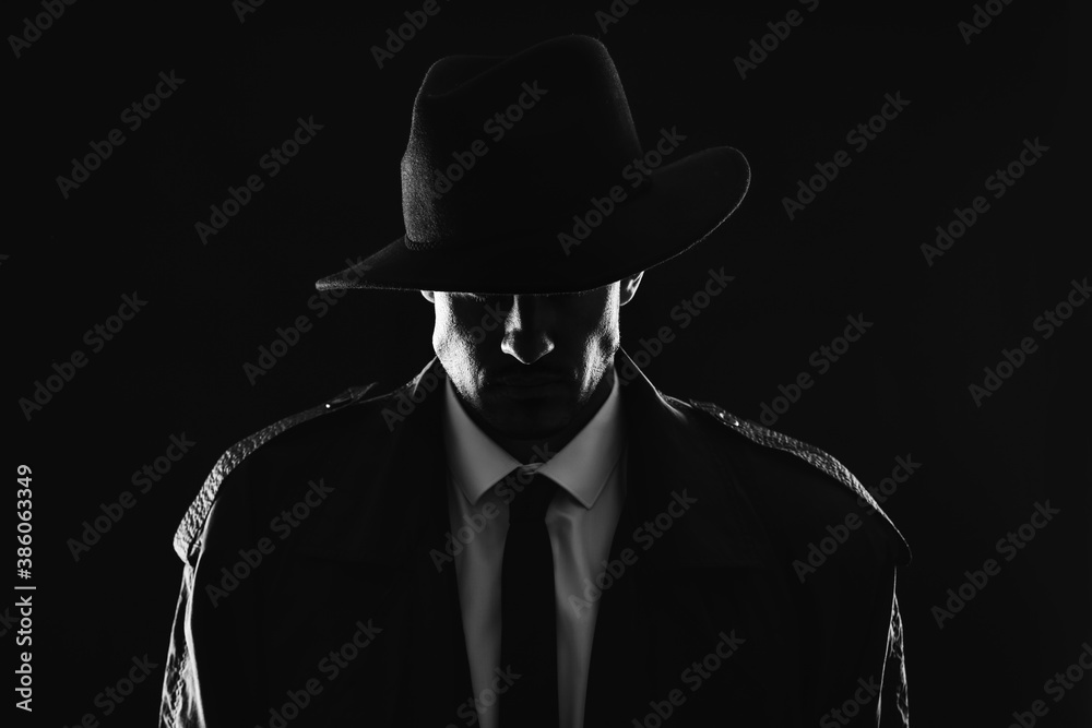Old fashioned detective in hat on dark background, black and white effect - obrazy, fototapety, plakaty 