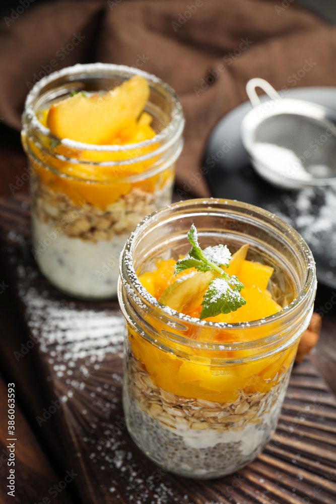 Tasty peach dessert with yogurt and granola on wooden table Tasty peach dessert with yogurt and granola on wooden table