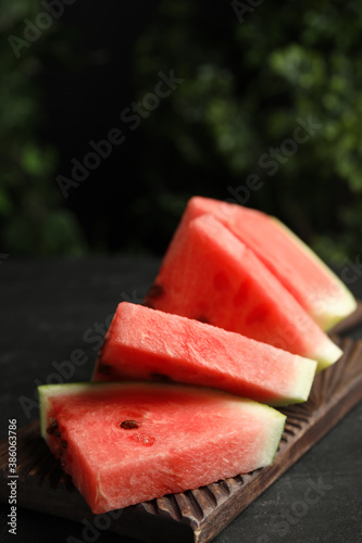Cut ripe watermelon on black table, closeup